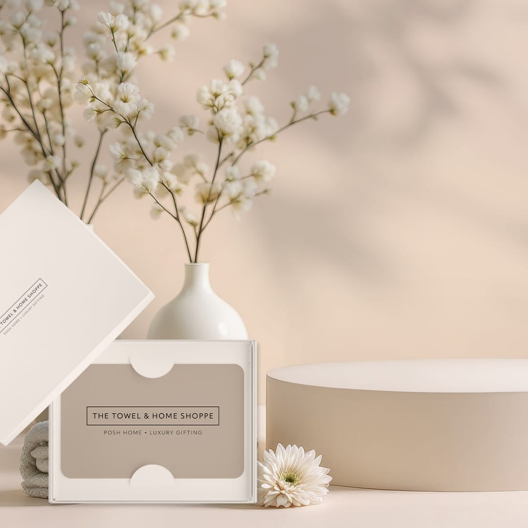 Product display with towels, a box, and decorative elements on a neutral background