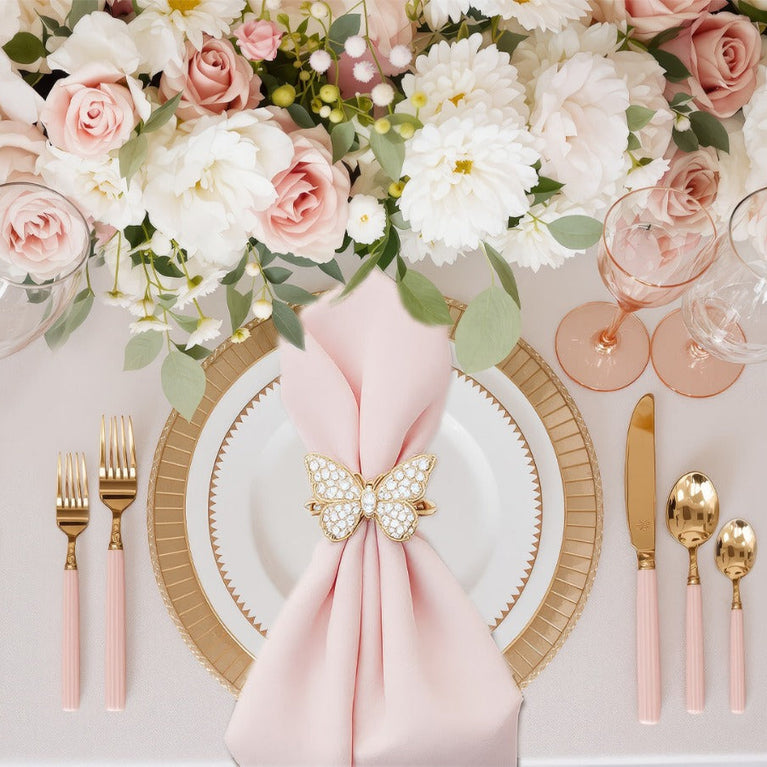 Elegant table setting with floral decorations, plates, and cutlery on a white background.